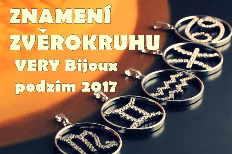 Stříbrné přívěsky s astrologickými znameními na tmavém pozadí.