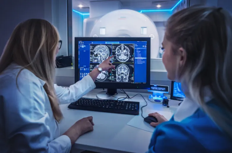 Dva lékaři studují magnetickou rezonanci mozku na obrazovce.