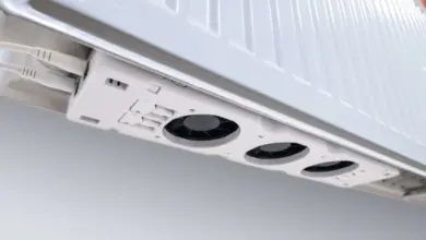 Bílý elektrický radiátor s viditelnými ventilátory pod tělesem.