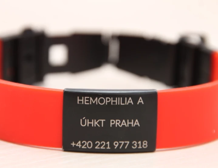 Červený náramek s výřezem pro hemofilii A od ÚKT Praha.