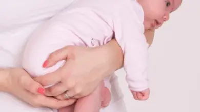 Matka drží dítě v poloze tygřík s neutrálním zády a bezpečným uchopení.