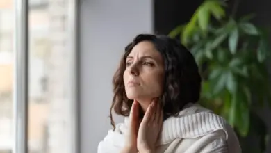 Woman holding throat in pain