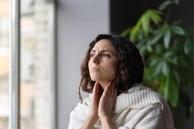 Woman holding throat in pain
