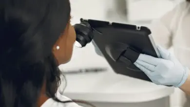 Dermatolog zkoumá kůži pacienta pomocí digitálního zařízení v ordinaci.
