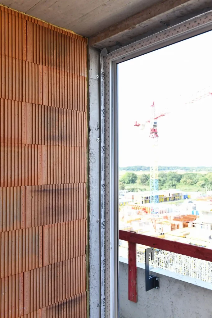 Detailní pohled na instalaci okenního rámu s izolační pěnou.