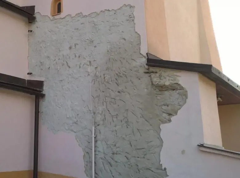 Velká část omítky na fasádě se odloupila.