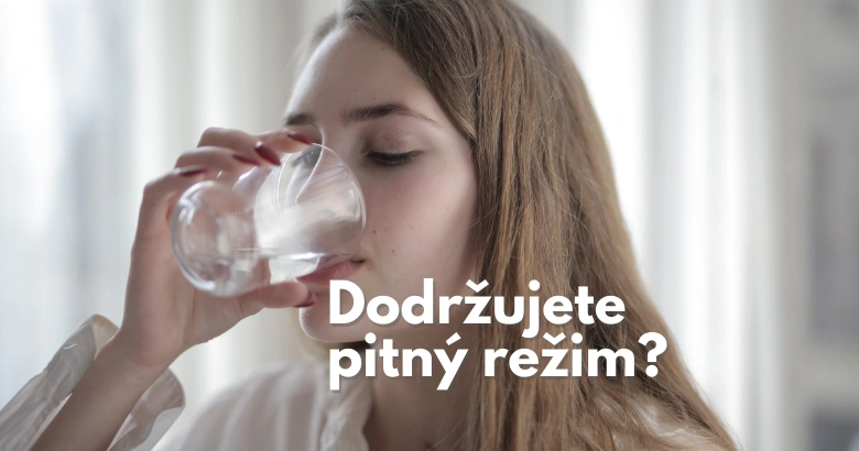 Mladá žena pije vodu z sklenice.