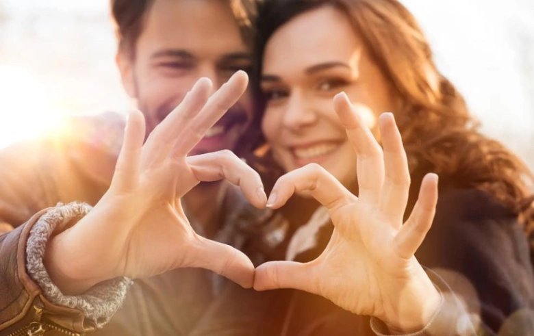 Couple making heart with hands