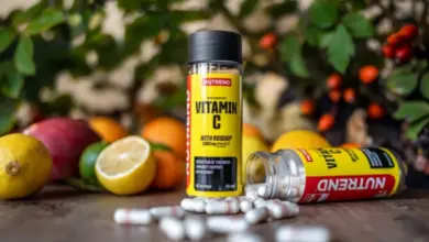 Doplňkový vitamín C s ovocem na dřevěném povrchu.