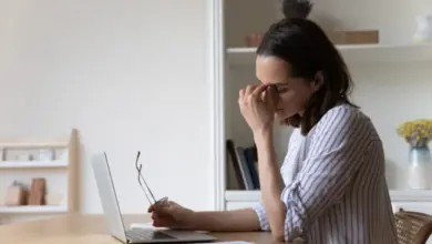 Žena sedí u počítače s výrazem apatie a únavy