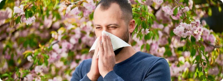 Man sneezing with tissue