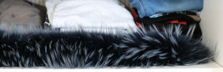Detail tmavé kožešiny na oblečení v šatníku.