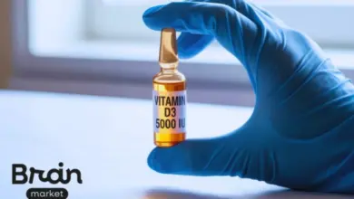 Ruka drží ampulku s vitamínem D3 o dávce 5000 ME.