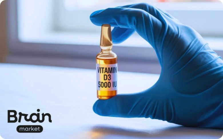 Ruka drží ampulku s vitamínem D3 o dávce 5000 ME.