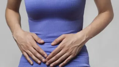 Žena drží ruce na břiše kvůli inkontinenci