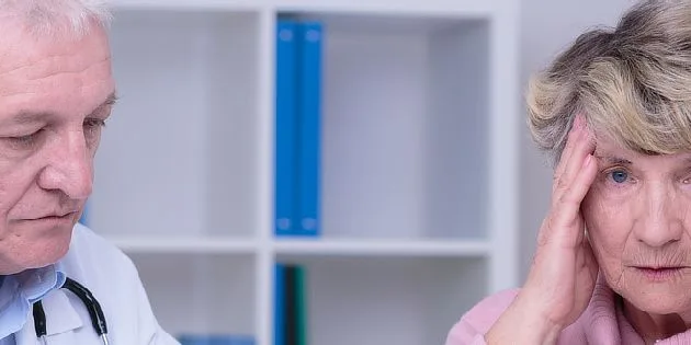 Starší žena s bolestí hlavy u lékaře v ordinaci