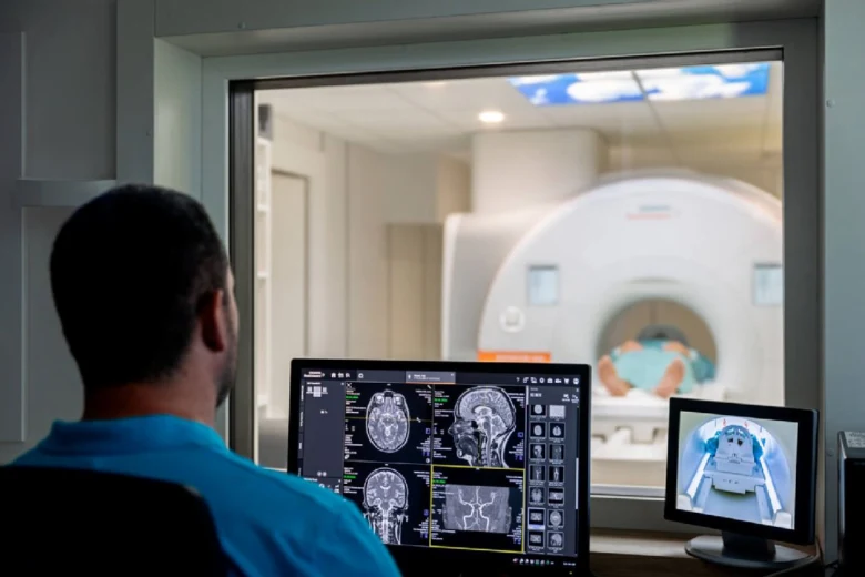 Technik sleduje magnetickou rezonanci na monitorech při vyšetření pacienta.