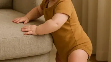 Miminko stojí s oporou o pohovku při vývoji chůze.