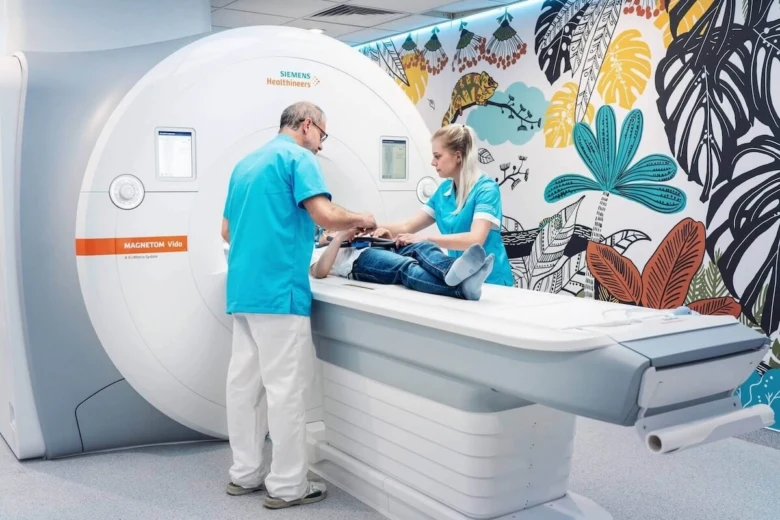 Lékaři pomáhají pacientovi při vyšetření na magnetické rezonanci.