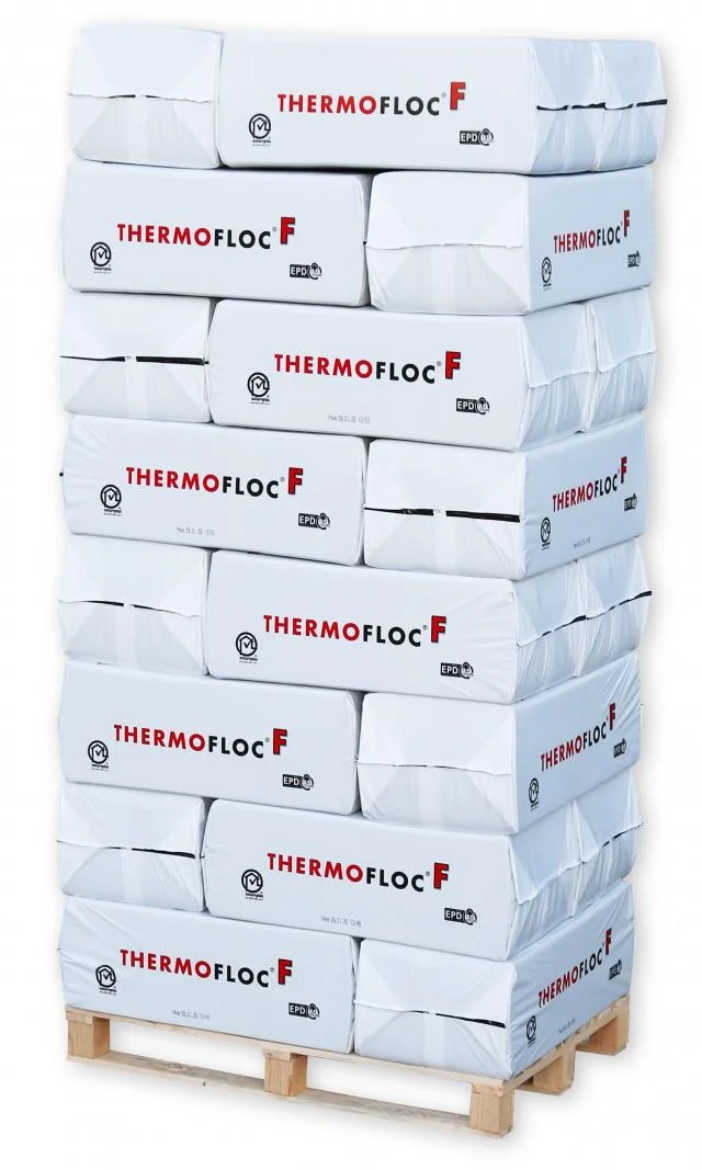 Balíky celulózy značky ThermoFloc na paletě pro tepelnou izolaci.
