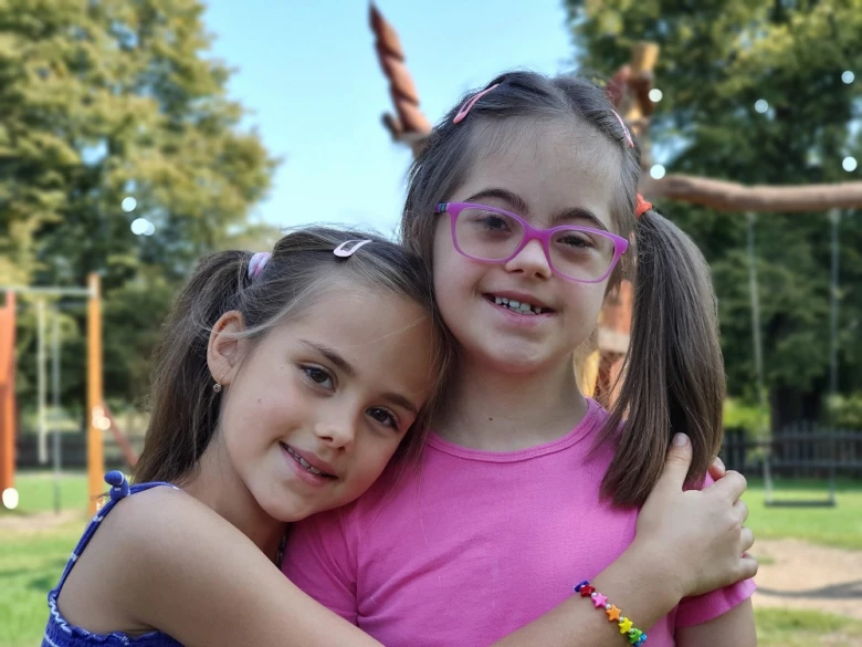 Two girls hugging outdoors