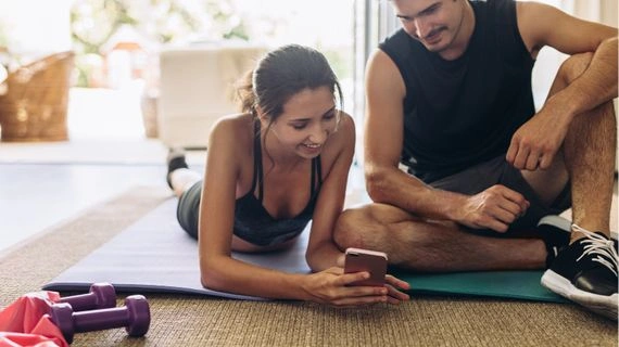 Couple on yoga mat with phone