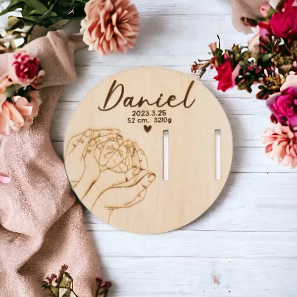 Dřevěný disk s gravírováním jména Daniel a stopkami pro vzpomínky.