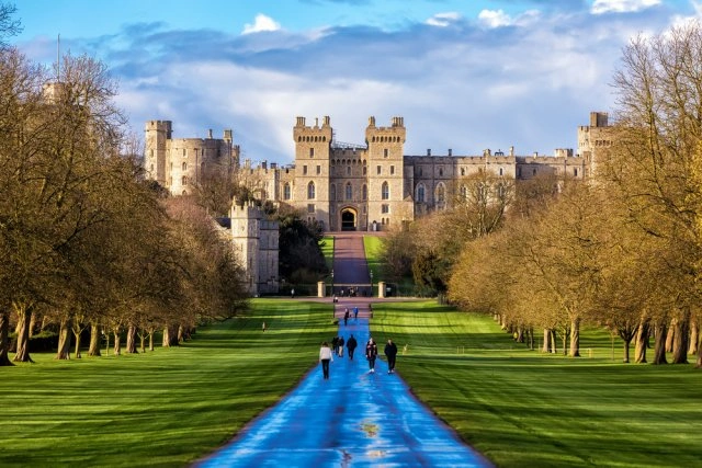 Vnější pohled na zámek Windsor v Anglii s cestou vedoucí k hlavní bráně.