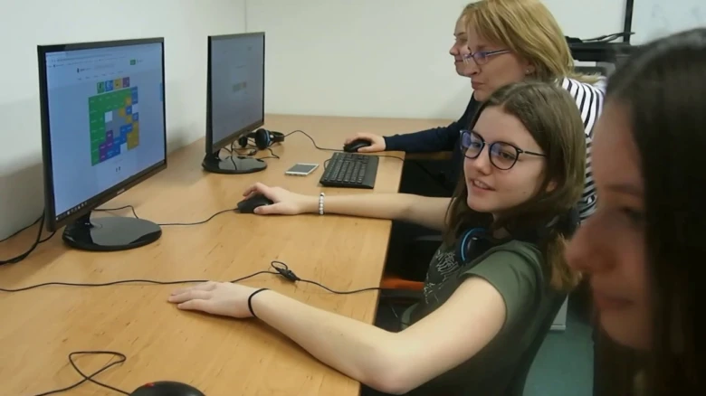 Lidé pracují na počítačích v kanceláři nebo třídě.