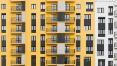 Moderní žlutá provětrávaná fasáda s balkony na bytovém domě.