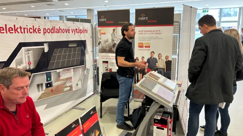 Muž prezentuje elektrické podlahové vytápění na výstavišti.