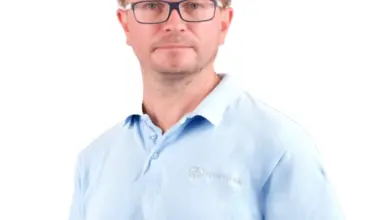 Muž v modrém tričku s logem společnosti.