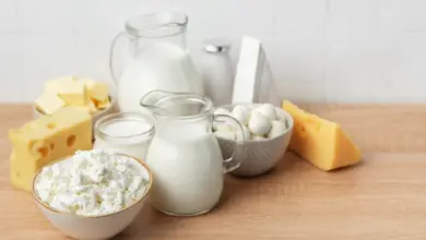 Různé mléčné výrobky jako sýry, jogurt a smetana na dřevěném povrchu.