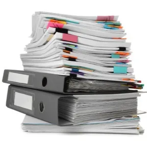 Hromada papírů v svazcích symbolizující administrativu.