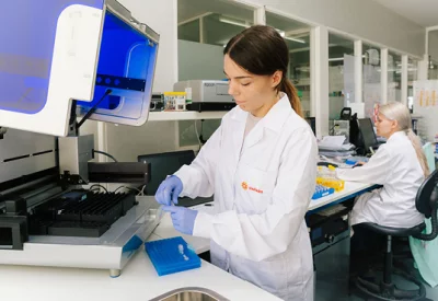 Žena v laboratoři pracuje s lékařským přístrojem.