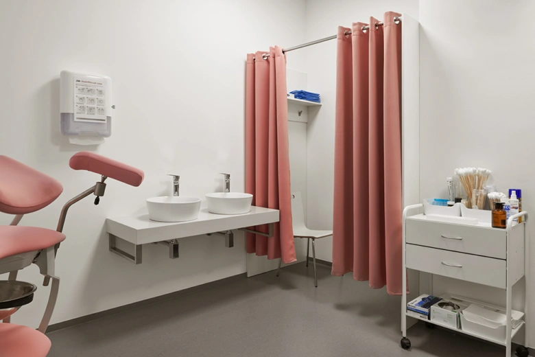Modern gynekologická ordinace s židličkou pro vyšetření.
