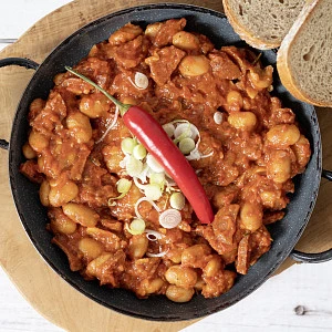 Pečené fazole s cibulkou a chilli v pánvi.