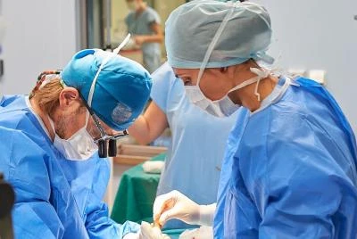 Chirurgové provádějí operaci kolene v operační sále.