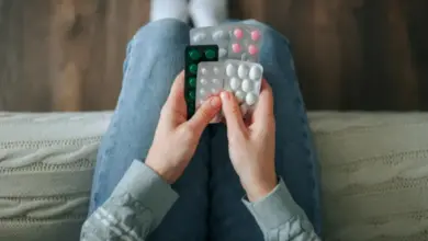 Ruce drží balíčky léků na nevolnost a motání hlavy.