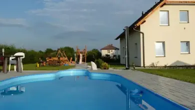 Bazén s hřištěm pro děti u domu v pozadí
