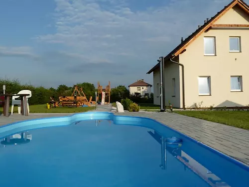 Bazén s hřištěm pro děti u domu v pozadí