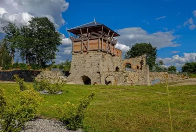 Historická věž s dřevěnou terasou v zeleném parku pro rodinné výlety.