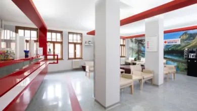 Modern interiér čekárny v lékařské ordinaci s červenými prvky.