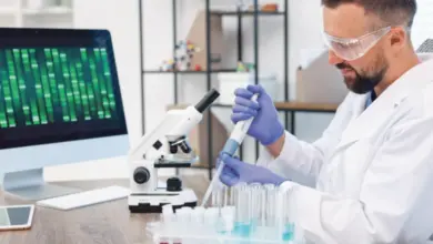 Vědec v laboratoři pracuje s mikroskopem a zkumavkami.