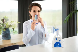 Žena používá modrý nosní inhalační přístroj k léčbě vysokého tlaku.